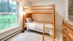 A bunk bed with a ladder, a bedside lamp, and a dresser with a television. - Cozy Campton Home: 10 Mi to Tenney Mountain Resort (Campton)