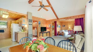 Een houten chalet inrichting met een eethoek, keuken en woonkamer.