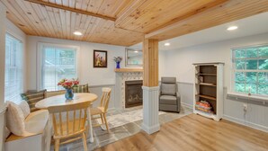 A cozy living room with a fireplace, a dining area with a table and chairs, and a bookshelf. - Charming Manheim Cottage w/ On-site Animal Viewing (Manheim)