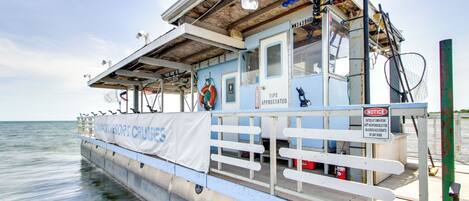 Um barco com corrimão branco, uma boia salva-vidas e uma placa indicando que gorjetas são bem-vindas.