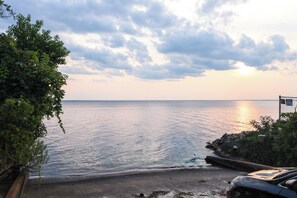 A coastal scene with a calm sea, a clear sky, and a signboard. - Multi-level Bonneau Cabin: Walk to Lake! (Bonneau)