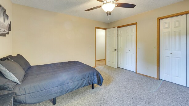 A bedroom with a bed, a ceiling fan, and a door leading to a closet. - Peaceful Pineville Vacation Rental w/ Grill! (Pineville)