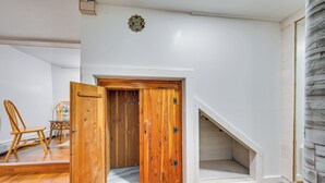 A room with a wooden door, a staircase, and a dining area with chairs and a table. - East Hartford Studio ~ 4 Mi to Downtown Hartford! (East Hartford)