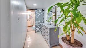 A hallway with a grey dresser, a potted plant, and a mirror. - East Hartford Studio ~ 4 Mi to Downtown Hartford! (East Hartford)