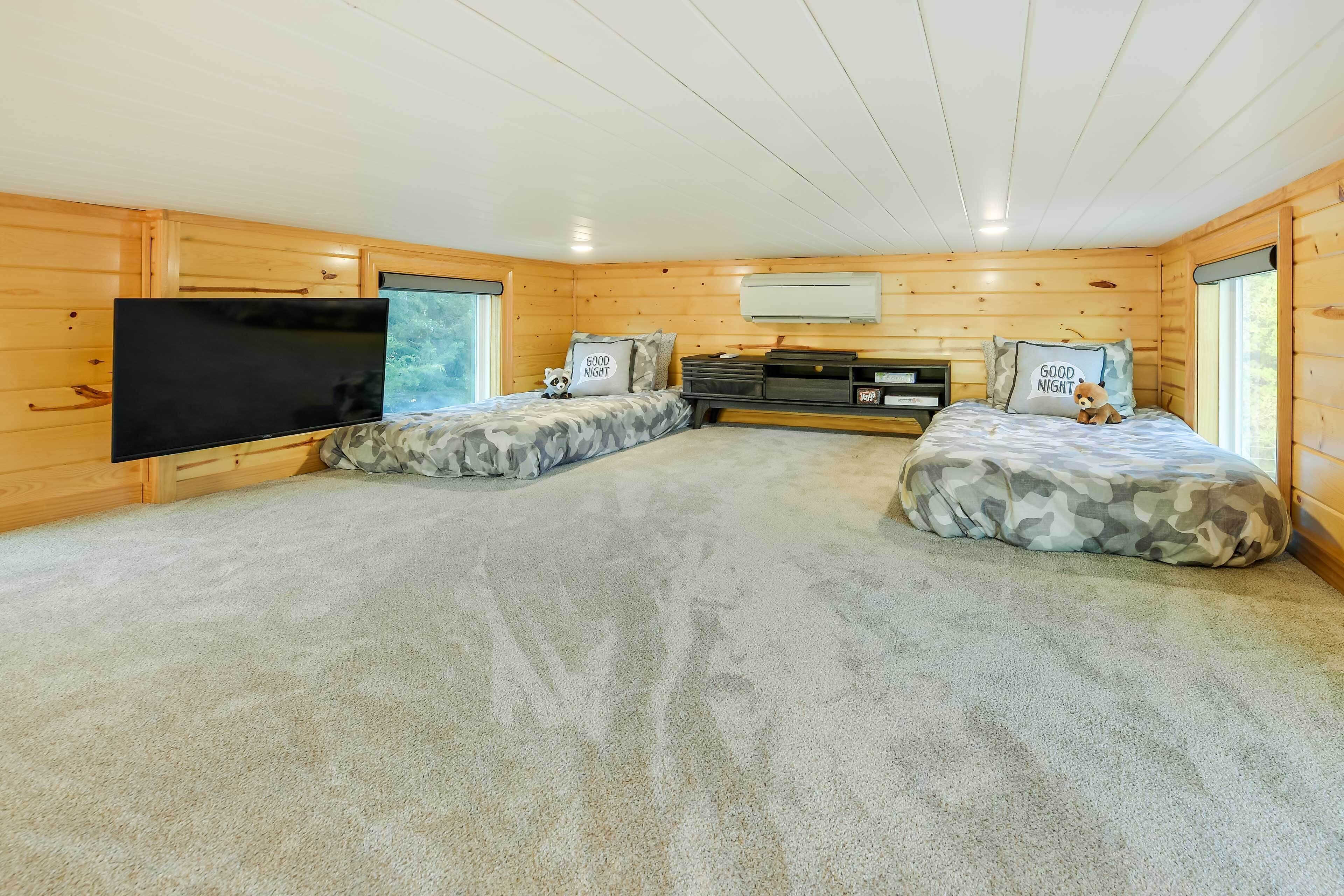 Ein gemütliches Cabin-Zimmer mit zwei Betten, einem Flachbildfernseher und einem Fenster.