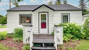 A small, single-story house with a front porch, a red door, and a mailbox. - Downtown Baudette Vacation Rental: Walk to Dining! (Baudette)