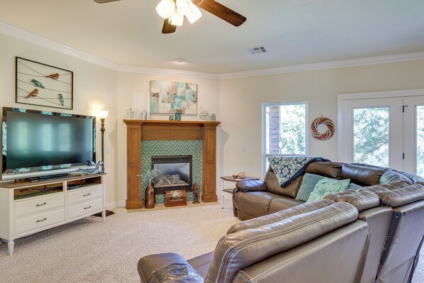 A living room with a fireplace, a television, and a leather sofa. - Quaint Noble Home: 6 Mi to University of Oklahoma! (Noble)