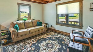 A cozy room with a leather sofa, a patterned rug, and a wooden ceiling. - Creek, Trails & Falls! Rural Red River Gorge Cabin (Campton)