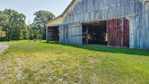 A large, rustic barn with open doors and a grassy area in front. - Creek, Trails & Falls! Rural Red River Gorge Cabin (Campton)