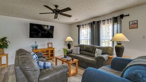 A living room with a ceiling fan, two couches, a TV, and two lamps. - Charming Smiths Grove Home Near Cave Tours! (Smiths Grove)