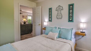 A bedroom with a large bed, a bedside table with a lamp, and a door leading to a bathroom. - Charming Smiths Grove Home Near Cave Tours! (Smiths Grove)