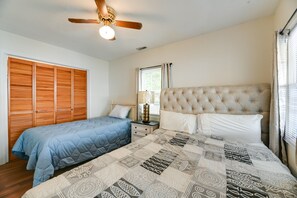 A bedroom with two beds, a ceiling fan, a window with curtains, and a wooden wardrobe. - Riverfront Edenton Condo w/ Porch & Water Views! (Edenton)