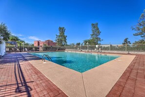 Relax by the clear pool surrounded by lounge chairs and umbrellas.