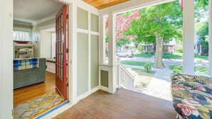 A porch with a wooden ceiling, a view of a street, and a lawn. - Cozy Michigan Retreat w/ Deck & Gas Grill! (Frankfort)