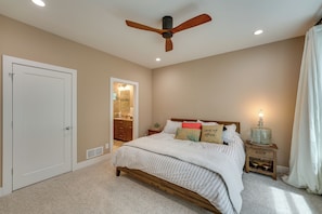 Cozy retreat with a large bed, nightstand, and ceiling fan.