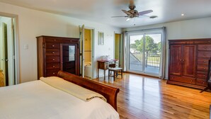 Un dormitorio con una cama grande, un armario de madera y un escritorio.