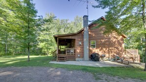 A rustic cabin with a porch, a chimney, and a picnic table. - Minnesota Cabin Rental: 3 Mi to Pelican Lake! (Pequot Lakes)