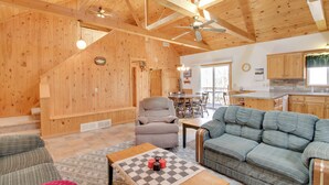 A wooden interior with a sofa, armchair, and a dining table. - Minnesota Cabin Rental: 3 Mi to Pelican Lake! (Pequot Lakes)