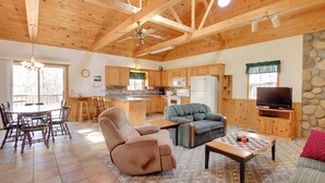A spacious living area with a dining table, sofas, a TV, and a kitchen in the background. - Minnesota Cabin Rental: 3 Mi to Pelican Lake! (Pequot Lakes)