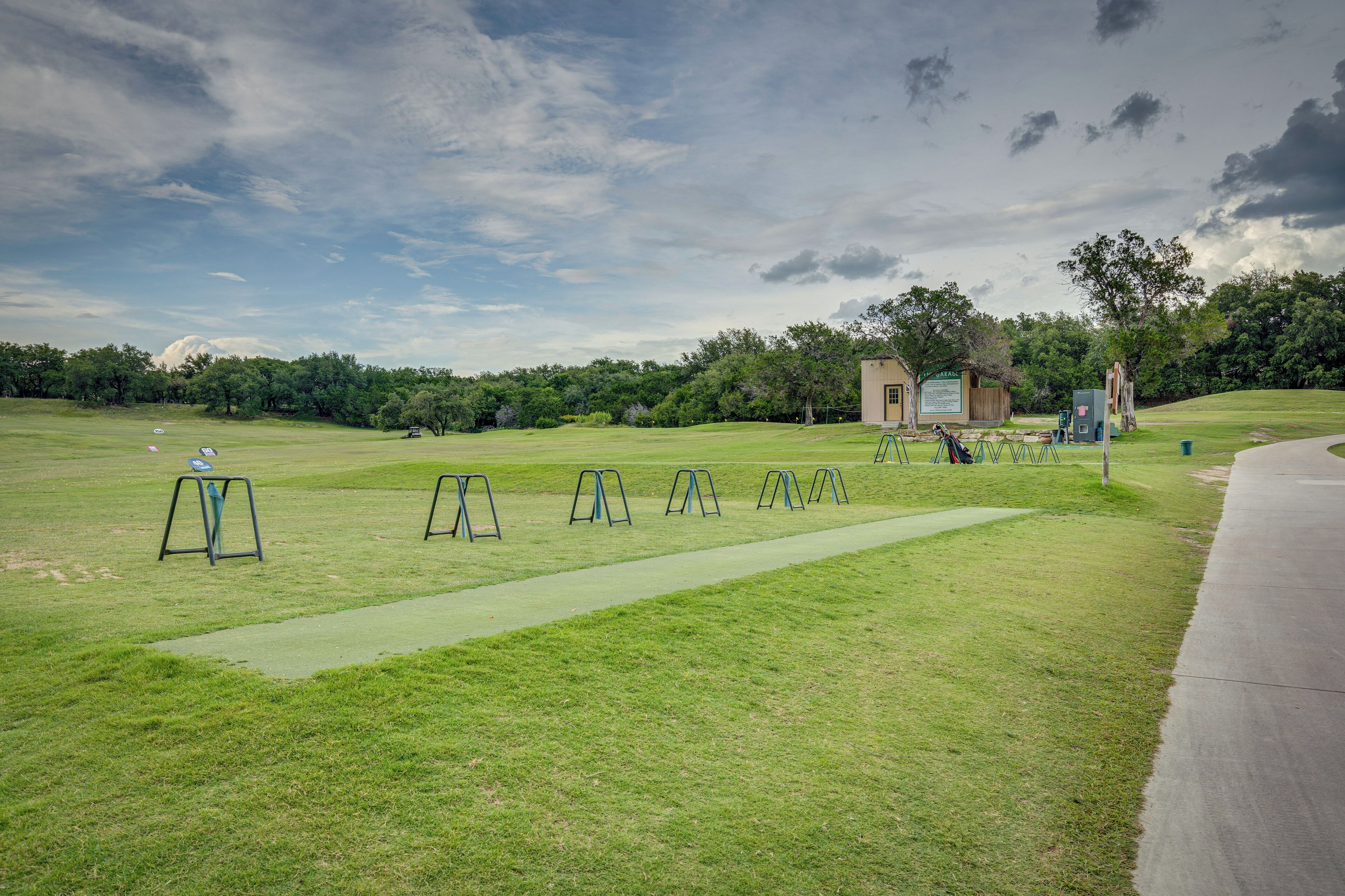 A grassy area with swings and a small building, likely a park or recreational area.