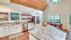 A spacious kitchen with white cabinetry, a granite countertop, and a wooden ceiling. - Luxe Kentucky Cabin Rental ~ 36 Mi to Mammoth Cave (Cub Run)