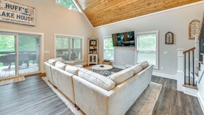 A spacious living room with a large sectional sofa, a wooden ceiling, and a TV mounted on the wall. - Luxe Kentucky Cabin Rental ~ 36 Mi to Mammoth Cave (Cub Run)