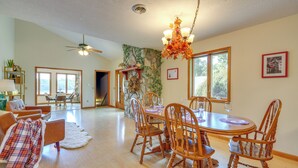 A spacious dining area with a round wooden table and matching chairs, a stone accent wall, and a ceiling fan. - Waterfront Bristol Area Retreat w/ Boat Dock (Blountville)