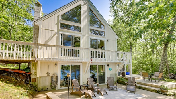 A two-story house with a balcony, outdoor seating area, and a covered patio. - Waterfront Lake Arrowhead Home w/ Dock! (North Waterboro)