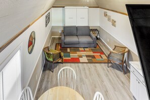 A compact living space with a sofa, chairs, a dining table, and a kitchenette. - Montezuma Vacation Rental With Fire Pit Access! (Montezuma)