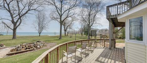 A wooden deck with chairs and a view of the lake.