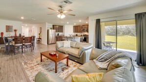 A spacious living room with a sofa, coffee table, and dining area.