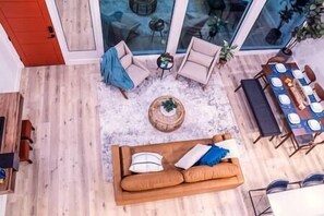 Un espacio de sala de estar integrado con sofá, mesa de centro y mesa de comedor.