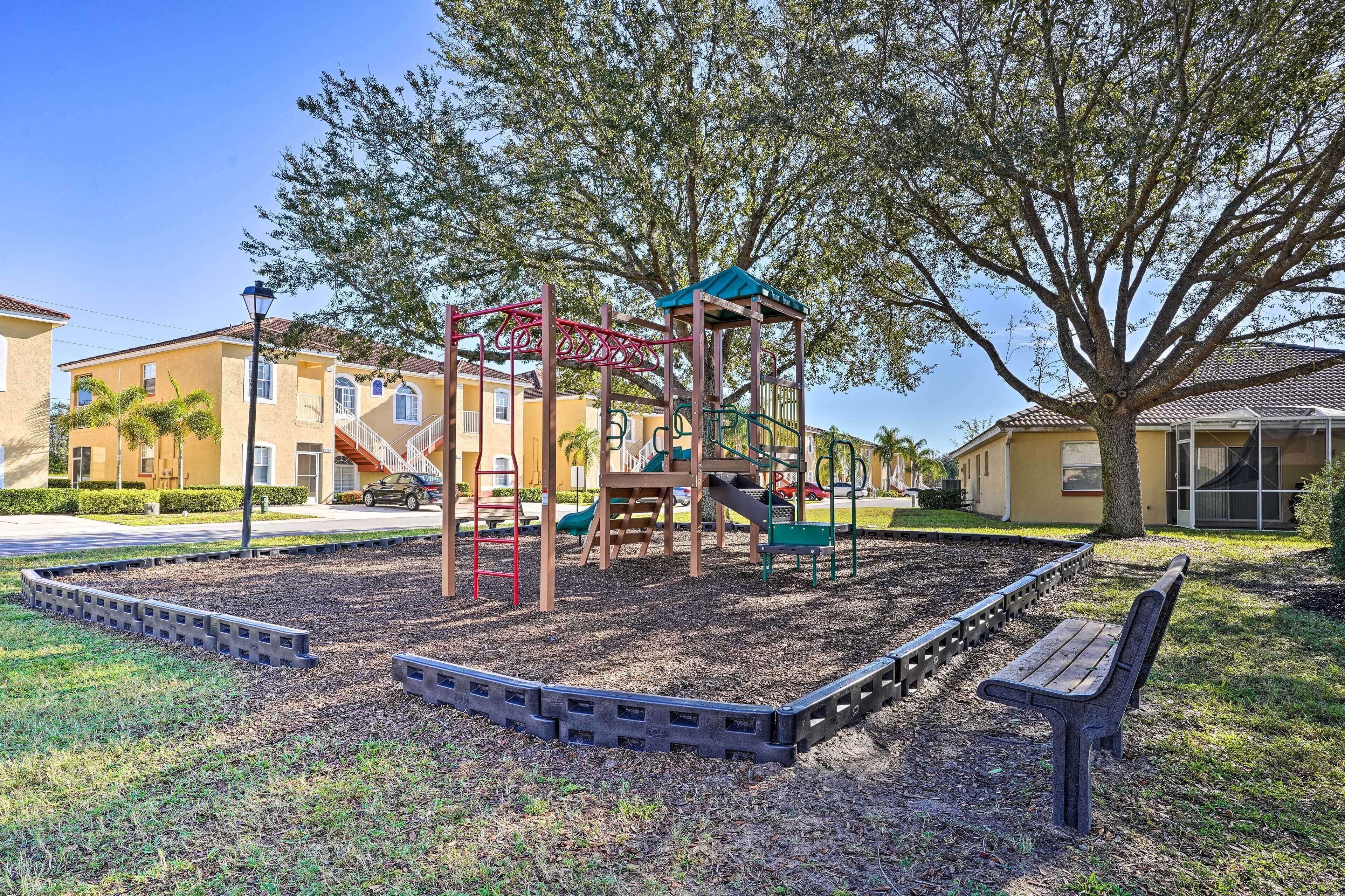 A playground with a slide, climbing structures, and a bench.
