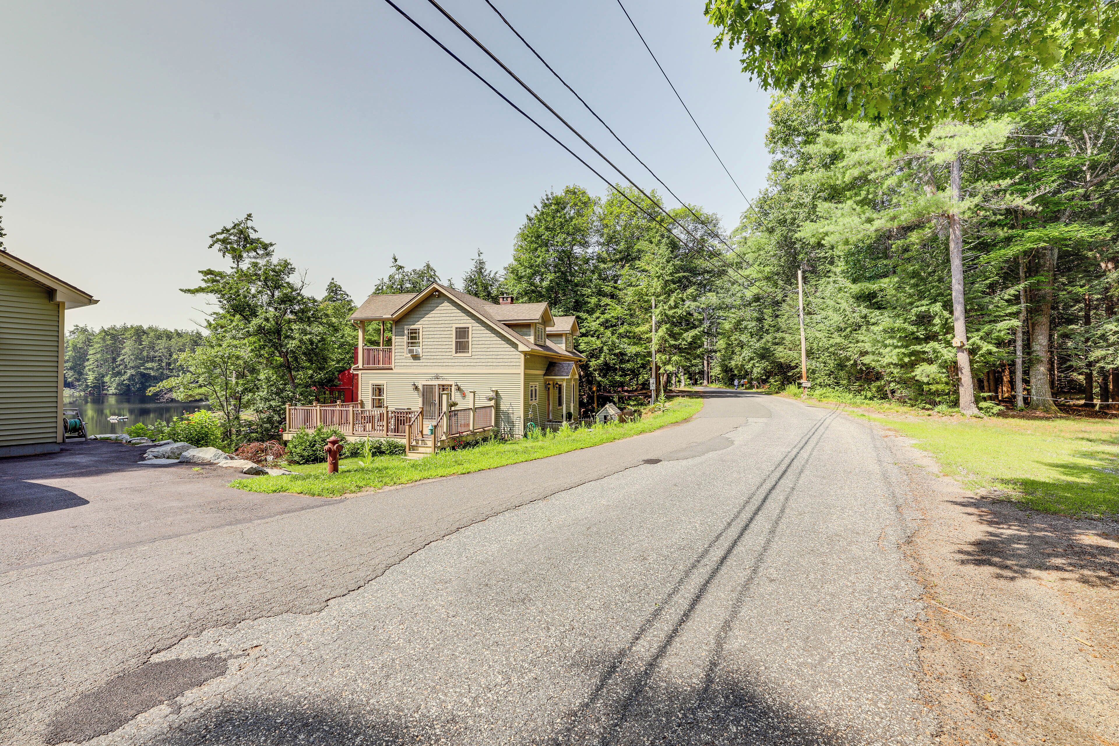 A residential street with houses on both sides, a clear sky, and a road curving ahead.