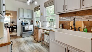 A kitchen with white cabinets, a wooden countertop, a built-in oven, and a large window. - Cozy Tennessee Abode w/ Private Hot Tub & Fire Pit (Winchester)