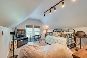 Cozy bedroom with a bed, desk, and TV, perfect for a restful stay.