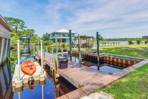 A waterfront property with a dock, a hot tub, and a house with a covered porch. - Waterfront Pensacola Paradise With Boat Slips! (Pensacola)