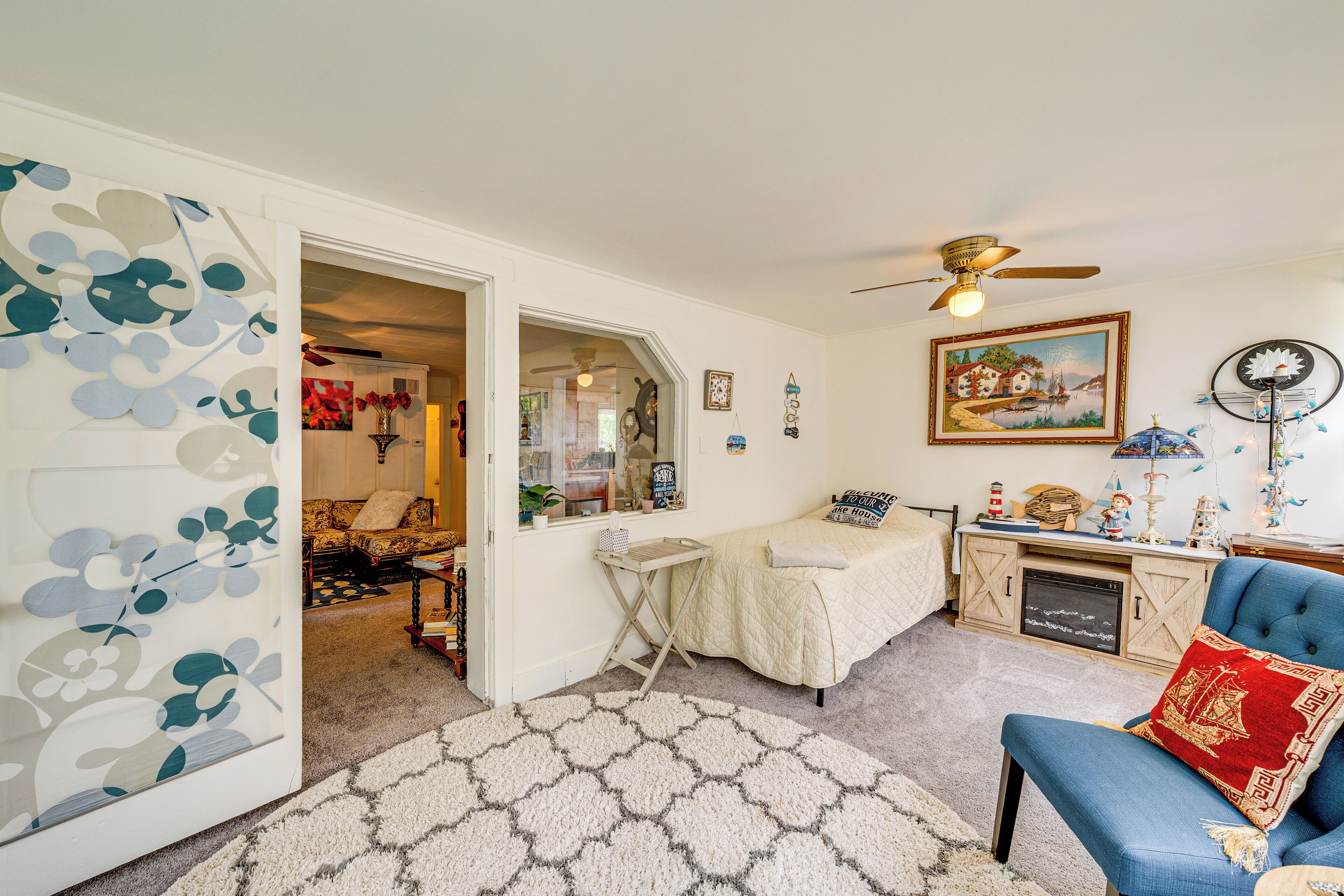 Une chambre à coucher avec un lit, un bureau, une chaise et un ventilateur de plafond.
