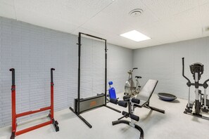 A gym with a pull-up bar, a stationary bike, a bench, and a weight bench. - Fayetteville Retreat' on 9 Acres Gym & Trails (Fayetteville)