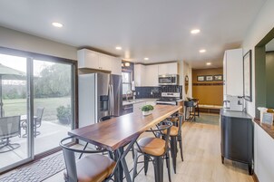 Una cocina moderna con una isla central, electrodomésticos de acero inoxidable y vistas al exterior.
