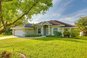 A two-story house with a garage, a well-maintained lawn, and mature trees. - Waterfront Lake Placid Home w/ Yard & Boat Launch! (Lake Placid)