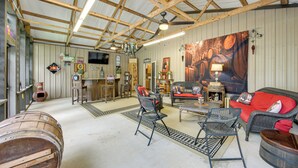 A rustic interior with wooden beams, a bar area, wicker furniture, and barrels. - Jefferson Vacation Rental With Golf Cart! (Jefferson)