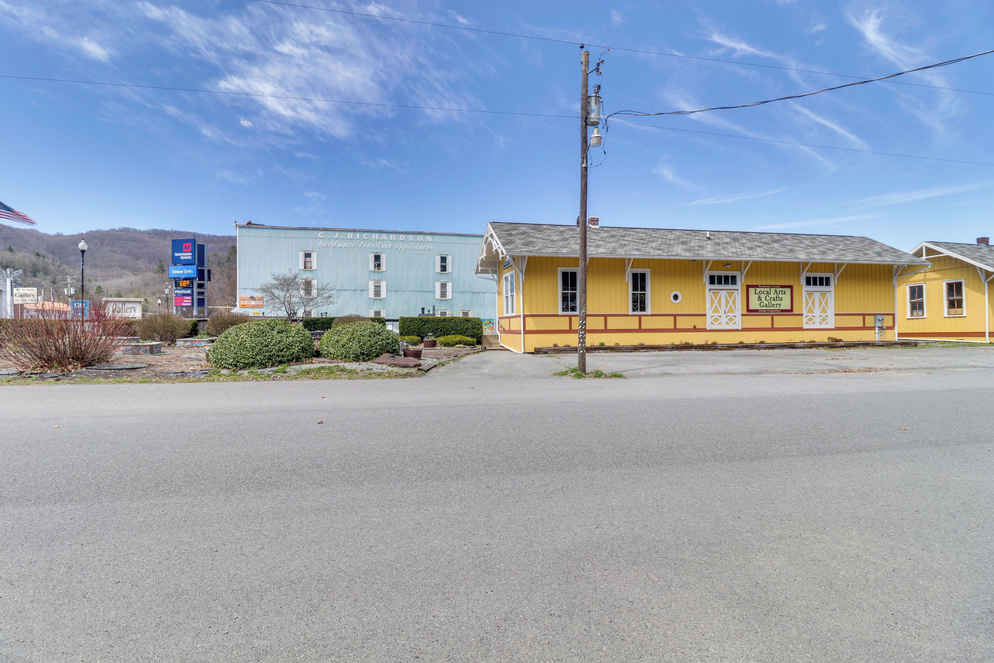 A yellow building with a sign for a local arts gallery.