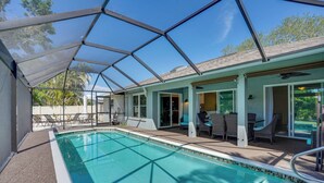 A covered swimming pool with a glass ceiling, outdoor seating, and a view of the surrounding area. - Cheery Fort Myers Vacation Rental w/ Private Pool! (Fort Myers)