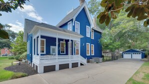 A two-story blue house with a porch, a garage, and a driveway. - WFH Friendly: Abode w/ Balcony in Columbus! (Columbus)