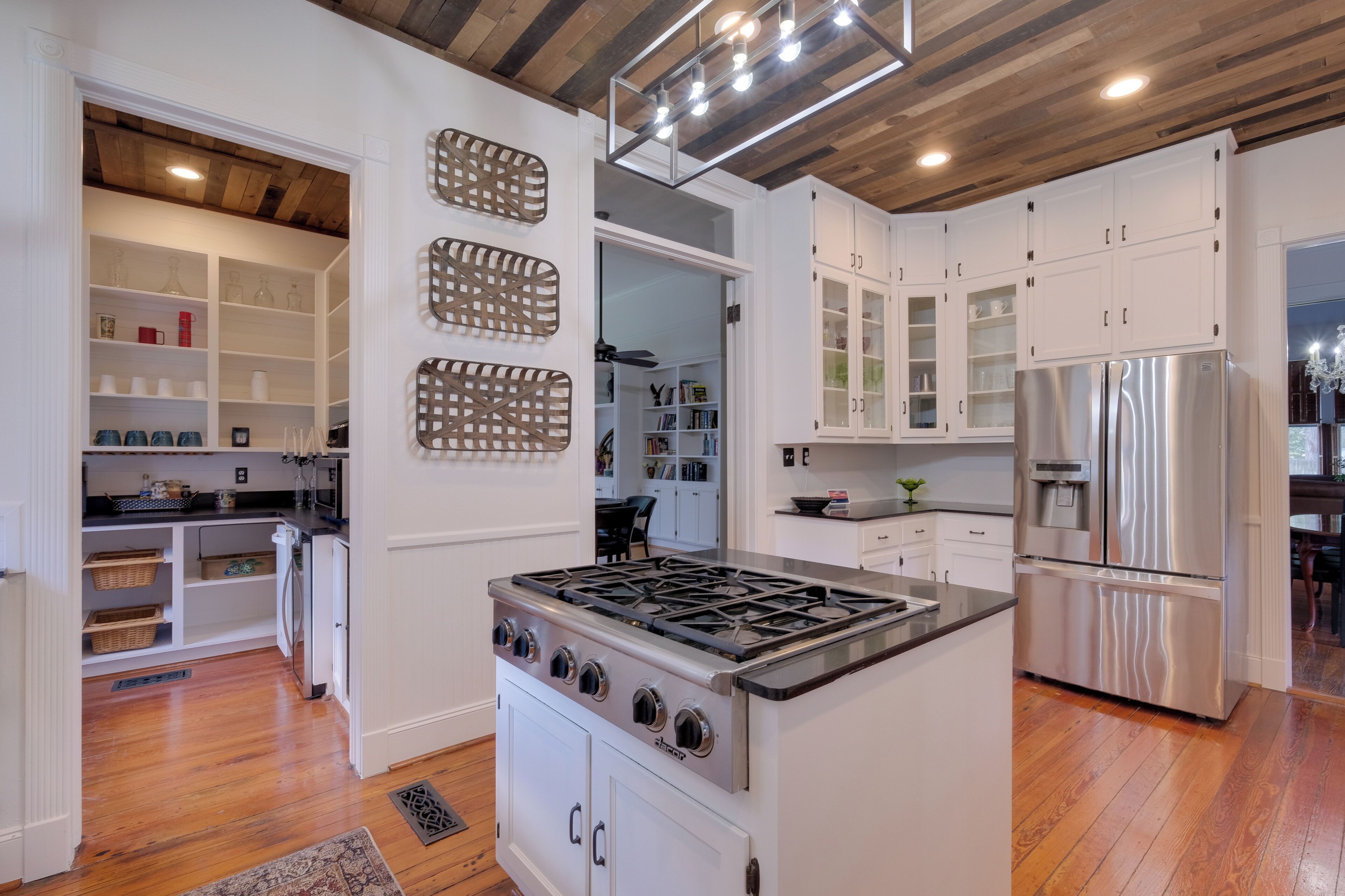A kitchen with white cabinets, a stainless steel refrigerator, and a gas stove.