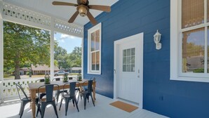 A covered porch with a dining table and chairs, a ceiling fan, and a white door. - WFH Friendly: Abode w/ Balcony in Columbus! (Columbus)