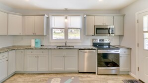 A modern kitchen with white cabinets, a stainless steel dishwasher, an oven, and a microwave. - Pet-friendly Connecticut Retreat Near Golfing! (Waterbury)