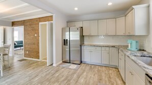 A modern kitchen with light-colored cabinets, a stainless steel refrigerator, and a granite countertop. - Pet-friendly Connecticut Retreat Near Golfing! (Waterbury)
