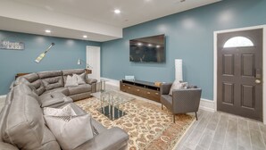 Ein modernes Wohnzimmer mit Ecksofa, Couchtisch und flachbildfernseher an der Wand.